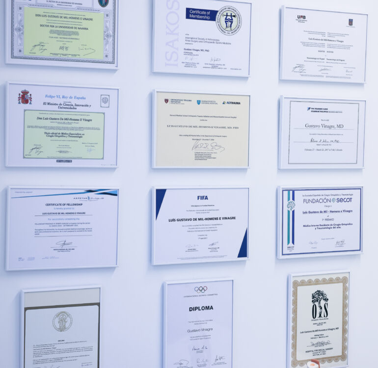 Parede com diplomas e certificados internacionais do Dr. Gustavo Vinagre